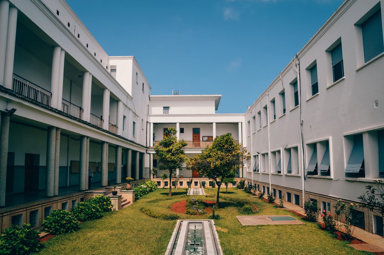 Elegant university building with garden courtyard in Rabat, Morocco under clear blue sky.